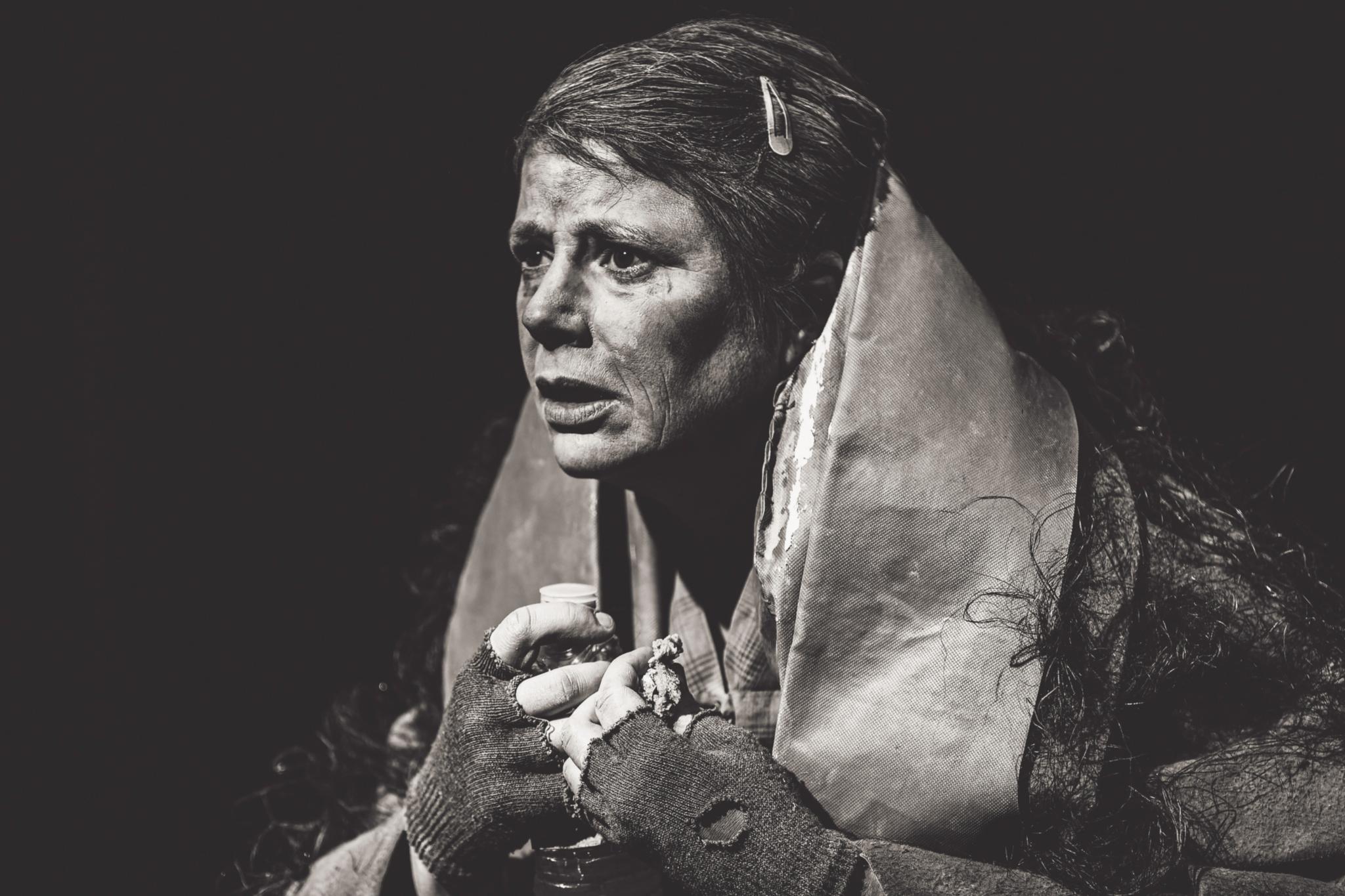 Schwarz-weiß-Aufnahme einer arm gekleideten Frau.