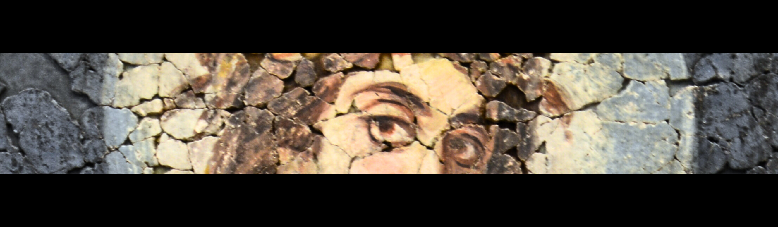 Detail der konstantinischen Deckenmalerei, zeigt die Augen einer Frau sowie Teile ihres Gesichts, Haare und einen Heiligenschein.