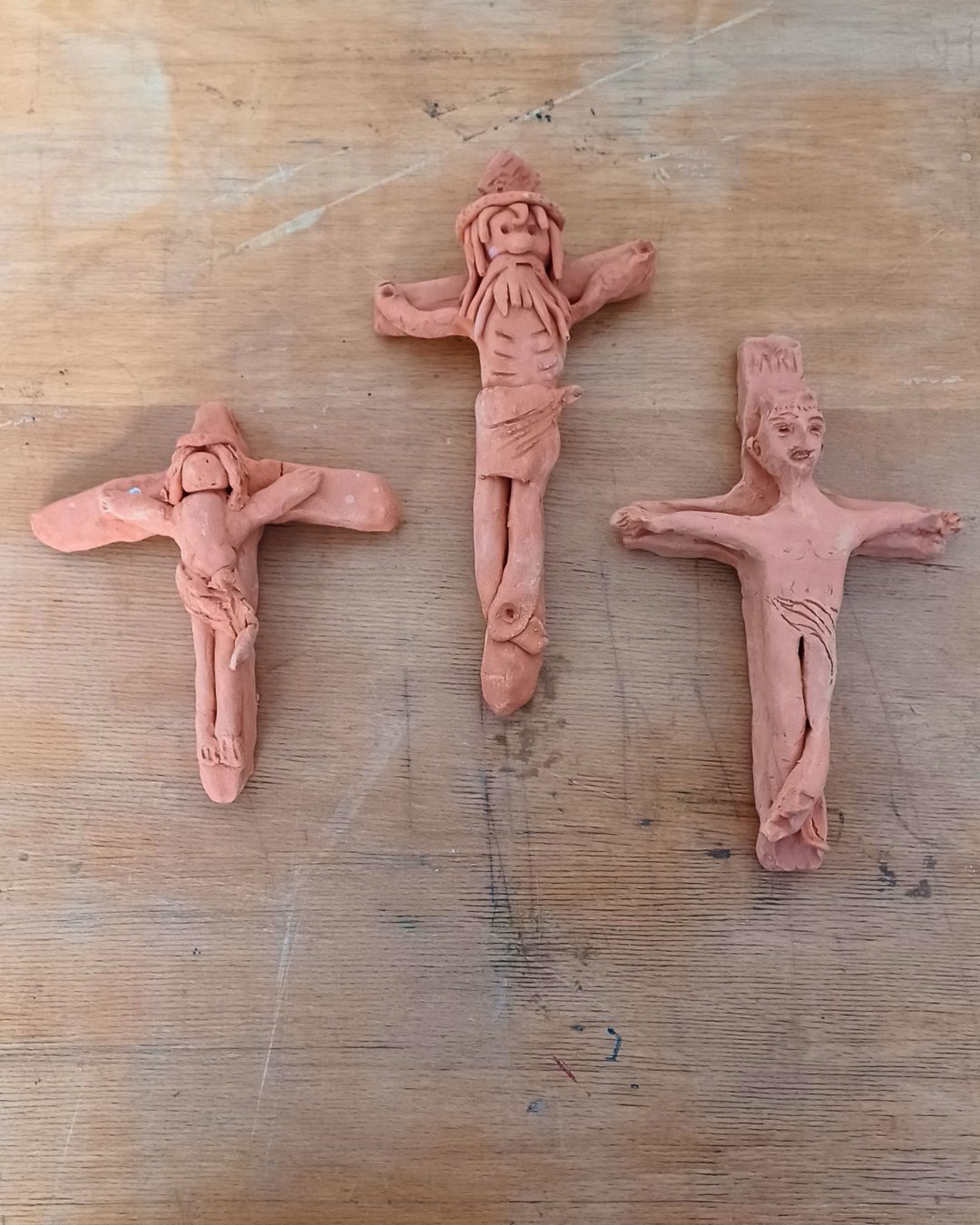 Drei von Kindern getöpferte Kreuze