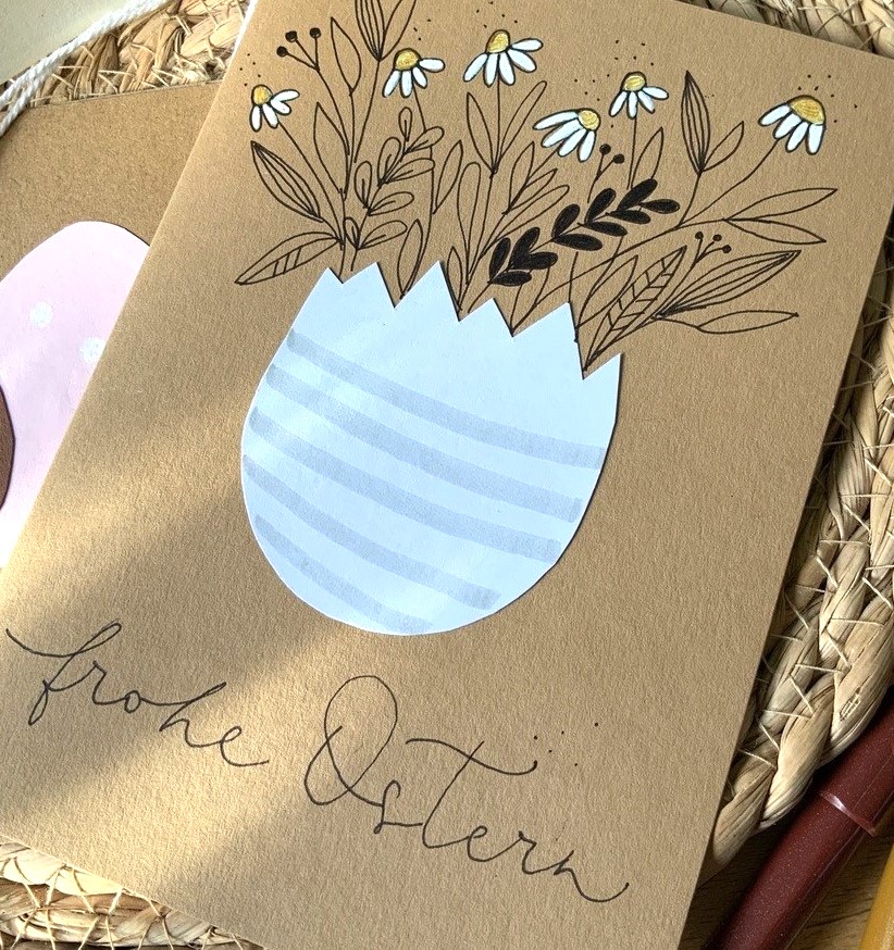 Kalligraphie-Osterkarte mit Blumen und dem Schriftzug 'Frohe Ostern'