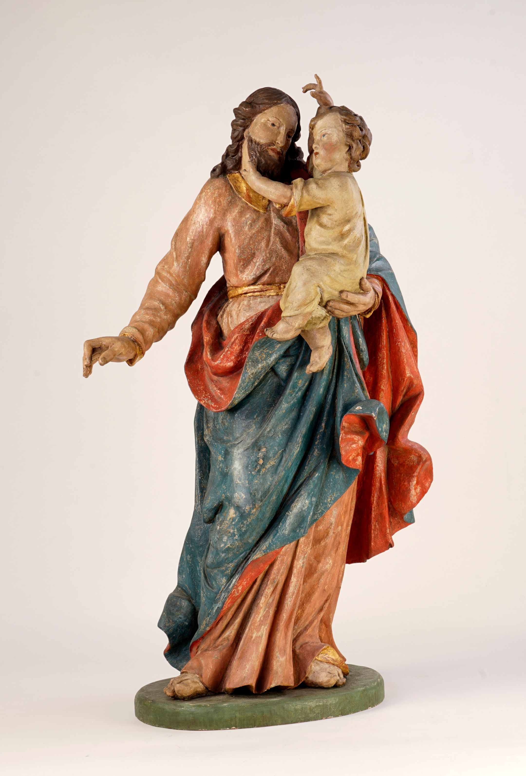 Josef, der Verlobte von Maria, hält das kleine Jesuskind auf dem Arm.